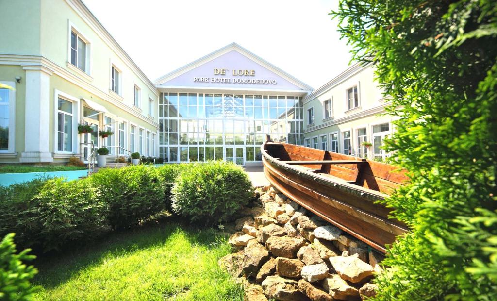 a building with a wooden boat in front of it at De`Lore Park Hotel Domodedovo in Domodedovo
