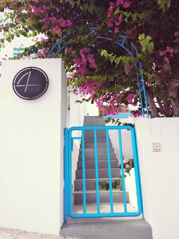 a blue gate leading up to some stairs with pink flowers at Alojamientos 4nudos in San José