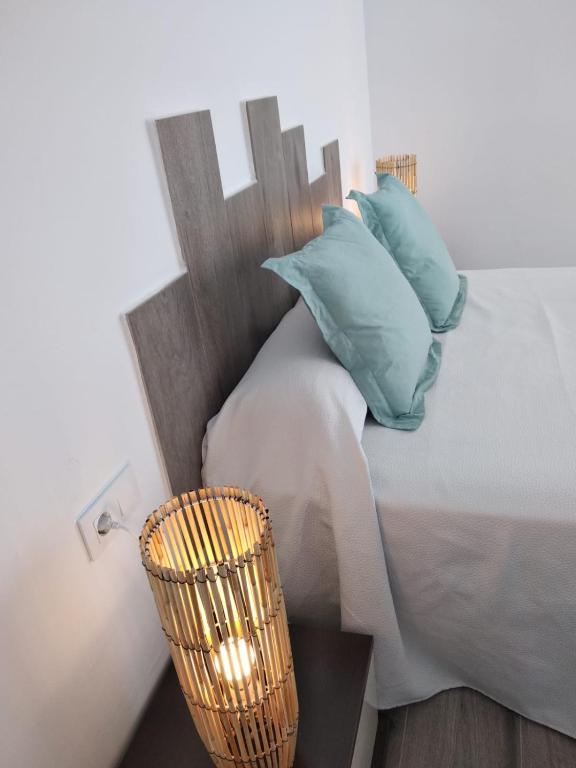 a bedroom with a bed with blue pillows and a basket at Alojamientos 4nudos in San José