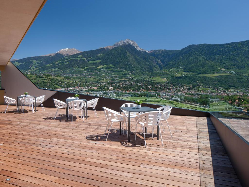 einen Tisch und Stühle auf einem Balkon mit Bergblick in der Unterkunft Hotel Marlena in Marling