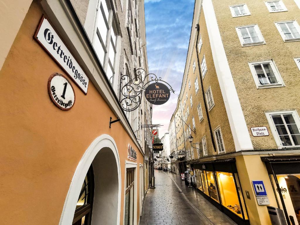 an alley with a clock on the side of a building at Hotel Elefant Family Business in Salzburg