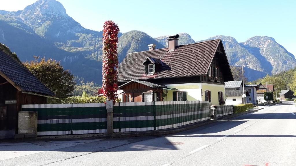 ein Haus mit einem Zaun mit Bergen im Hintergrund in der Unterkunft Haus Fratnik in Obertraun