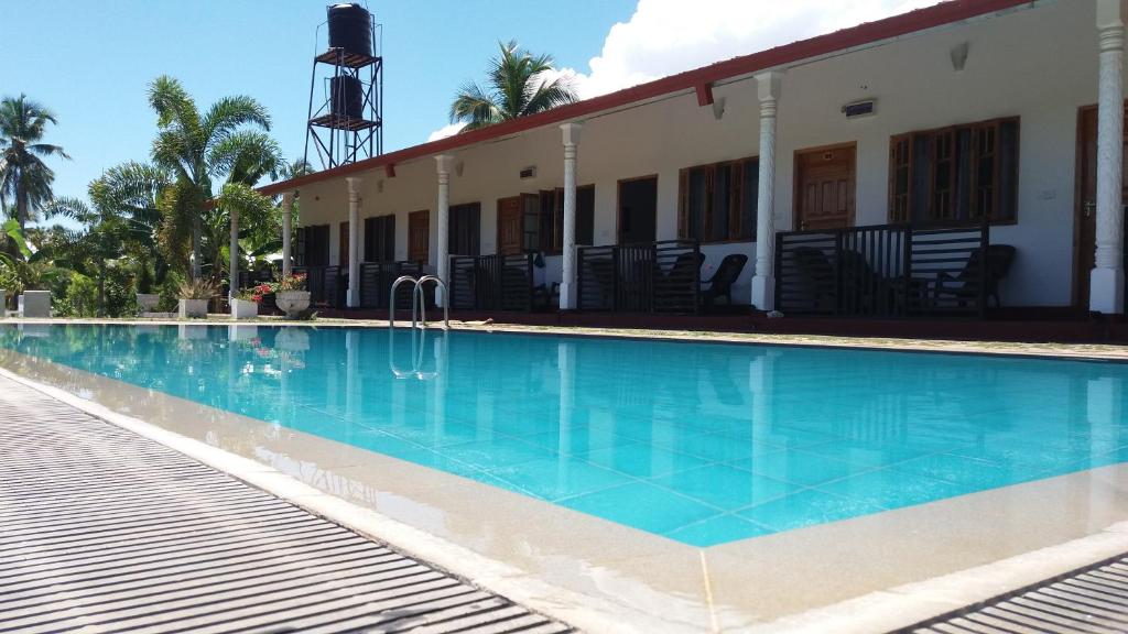 a large swimming pool next to a building at Shan Guest and Restaurant Nilaveli in Trincomalee