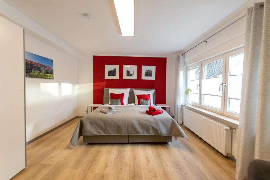 1 dormitorio con 1 cama grande y paredes rojas en Fewo Lindenstrasse en Großrudestedt