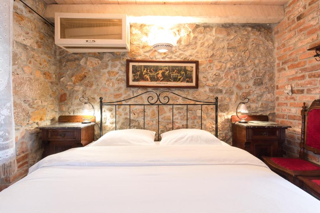a bedroom with a bed in a stone wall at Holiday Home Bozanić in Vrbnik