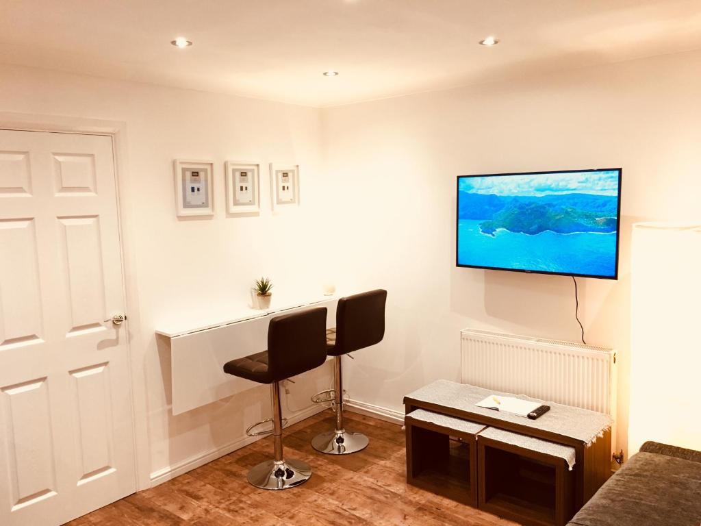 ein Wohnzimmer mit einem TV an der Wand in der Unterkunft Fountain View 1BR Flat Oxford - Free Parking in Oxford