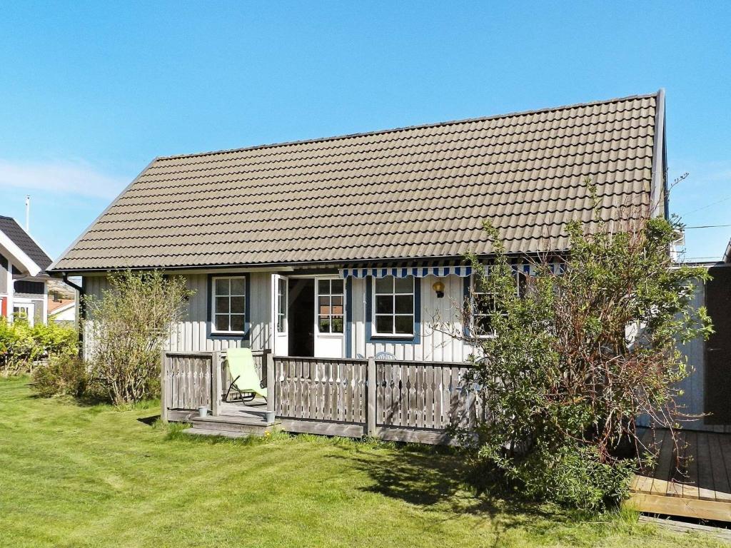 a small white house with a wooden fence at Three-Bedroom Holiday home in Lysekil 4 in Lysekil