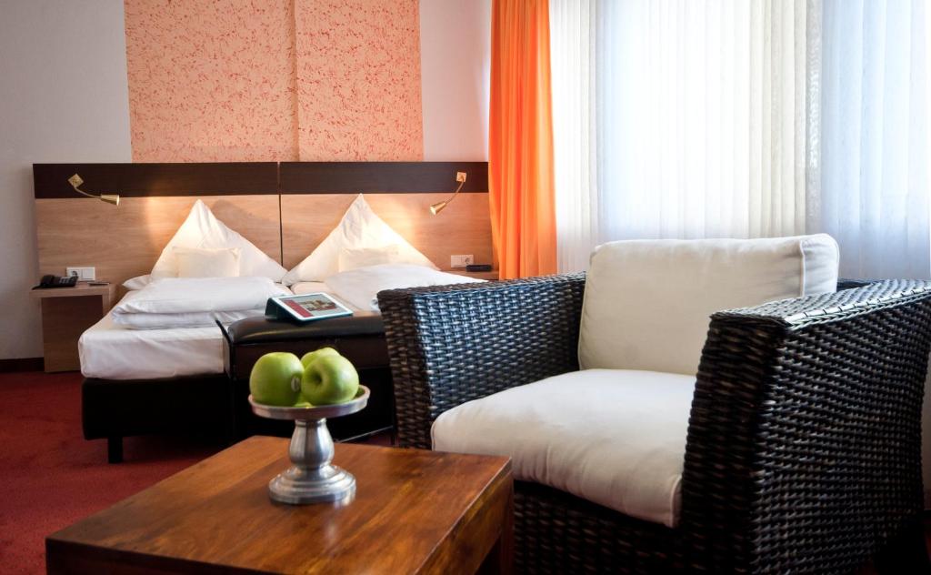 a hotel room with a bed and a couch and a table at Hotel Cascade Superior in Düsseldorf