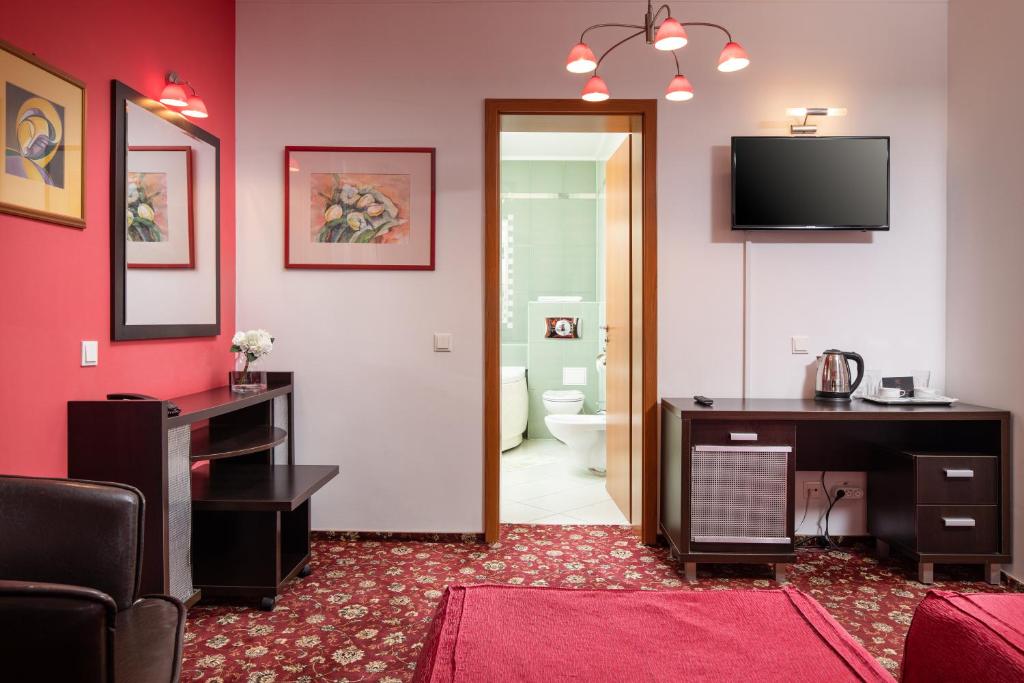 a room with a bathroom with a television on the wall at Grand Hotel in Braşov