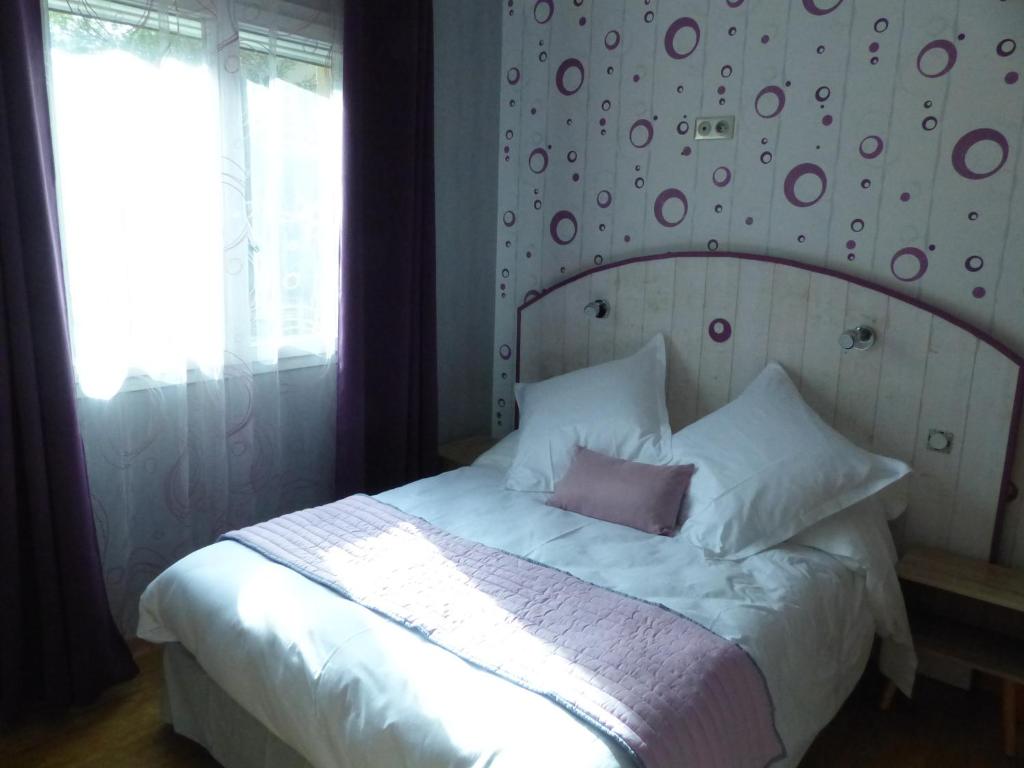 1 dormitorio con 1 cama blanca grande y pared en AU CLOS DE L'ETANG en Ravel