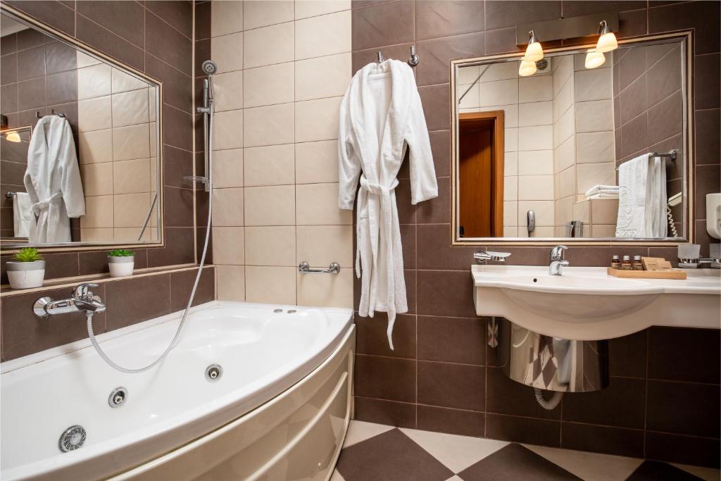 a bathroom with a tub and a sink at Grand Hotel in Braşov