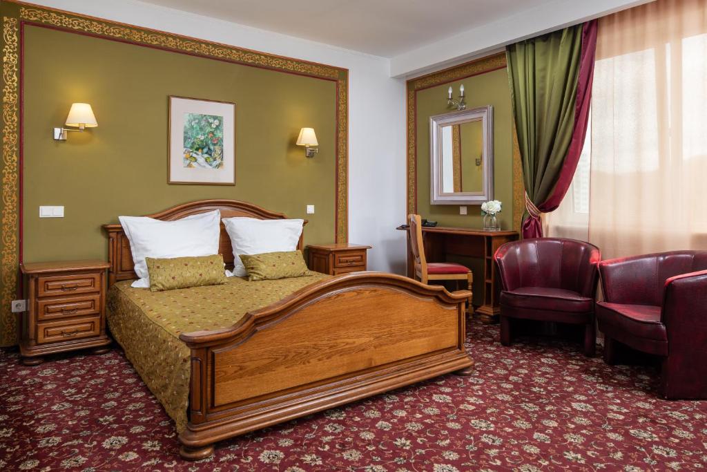 a hotel room with a bed and a desk at Grand Hotel in Braşov
