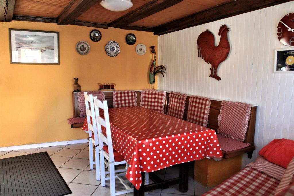 une salle à manger avec une table et un poulet sur le mur dans l'établissement Gite Loredana, à Kirchberg