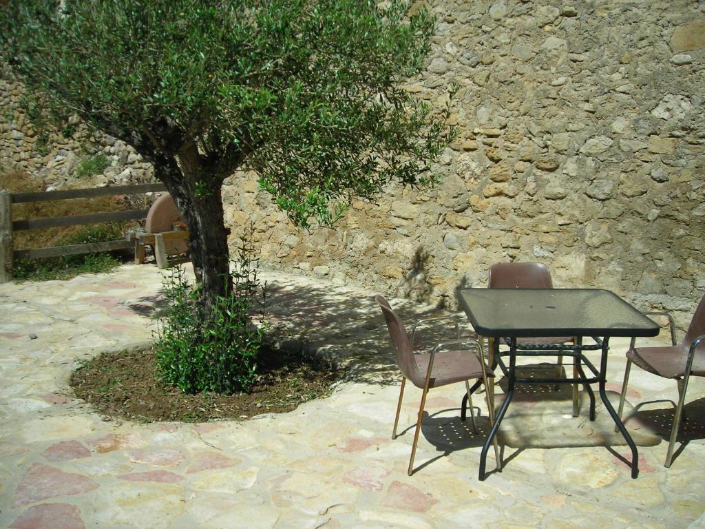 stół i krzesła siedzące obok drzewa w obiekcie Casestonet w mieście Forcall