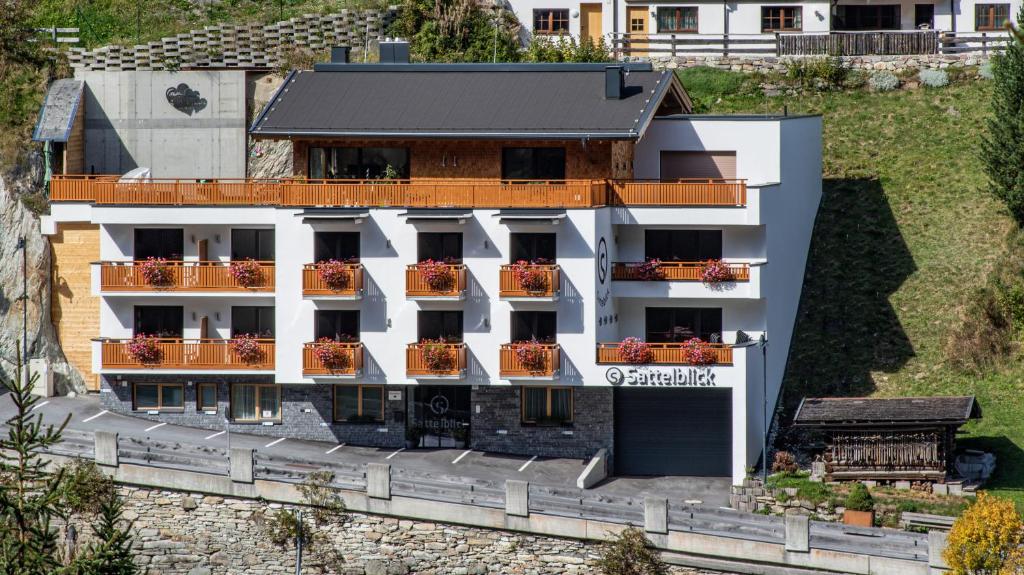 un edificio bianco con balconi e fiori di Haus Sattelblick a Sankt Anton am Arlberg