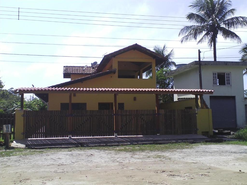 a yellow house with a fence in front of it at Makitub in Boracéia