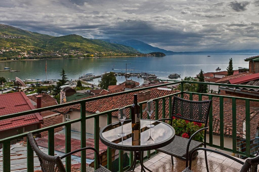 a table and chairs on a balcony with a view of a lake at INES APARTMENTS in Ohrid