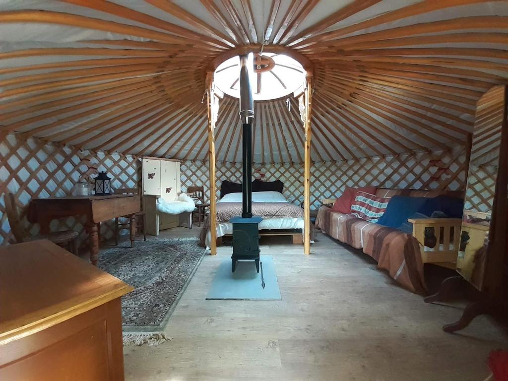a room with a yurt with a bed and a desk at Oakdean Cottage Yurt in Blakeney