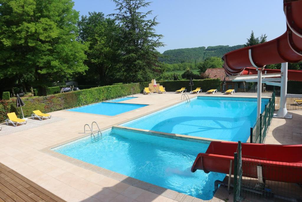 uma grande piscina com escorrega num resort em Camping Paradis Le Céou em Saint-Cybranet