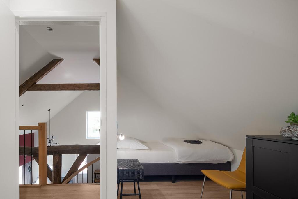 een slaapkamer met een bed en een tafel en stoelen bij De Stal in Kaatsheuvel