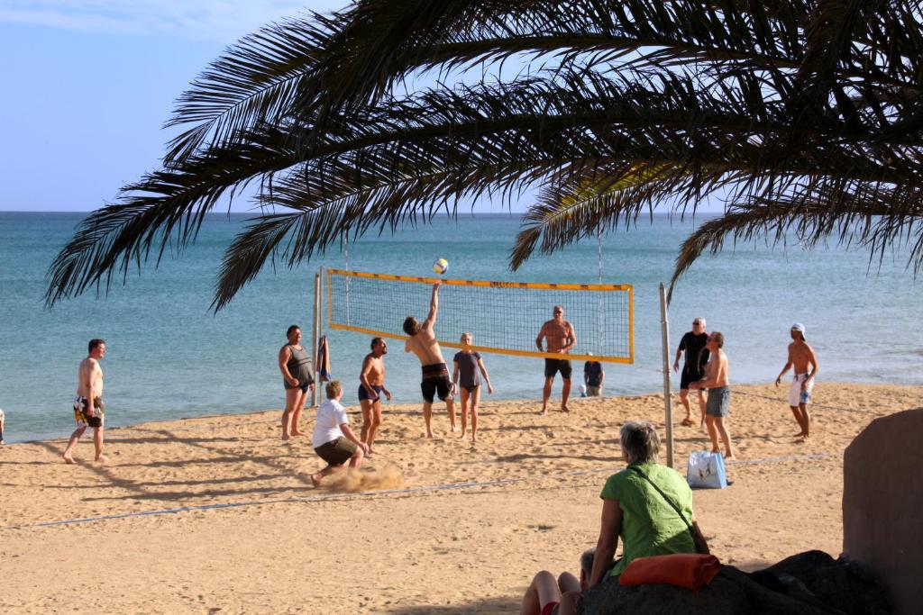 a group of people playing volleyball on the beach at Sotavento Beach Club in Costa Calma