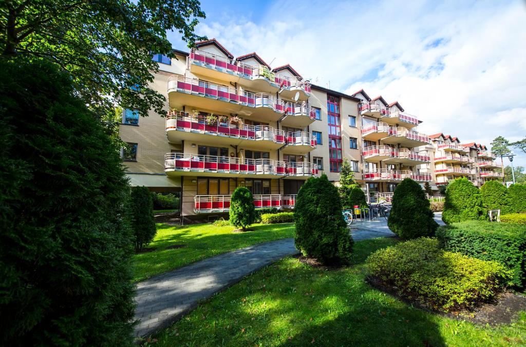 a large apartment building with bushes in front of it at Wyspa Uznam - Apartamenty Zdrojowa in Świnoujście