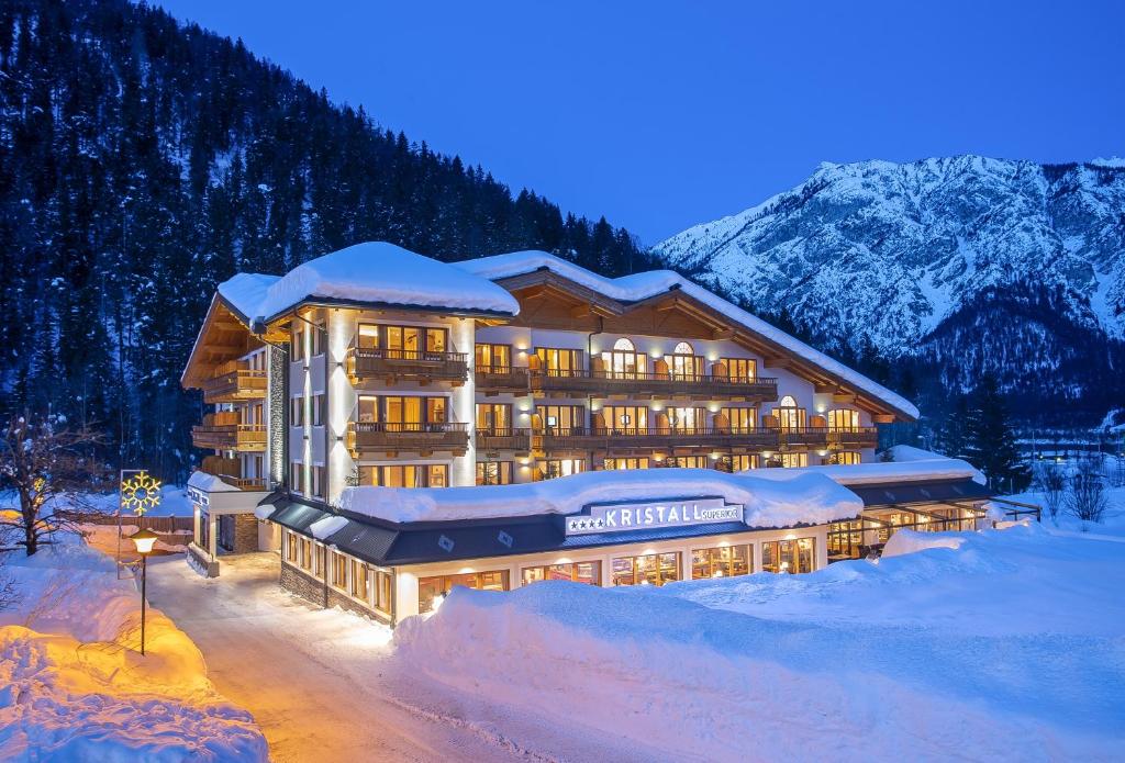 a large building in the snow at night at Verwöhnhotel Kristall in Pertisau