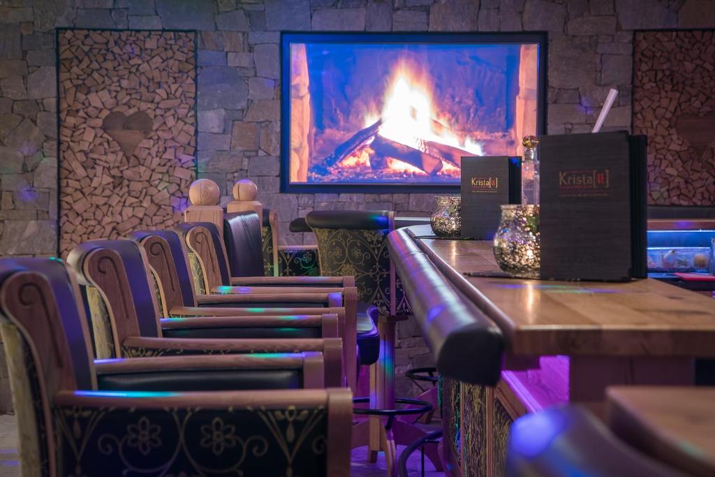 a bar with chairs and a fireplace in a room at Verwöhnhotel Kristall in Pertisau