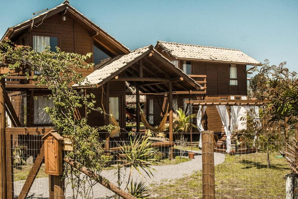 a wooden house with a fence in front of it at Cabanas Mahalo in Imbituba