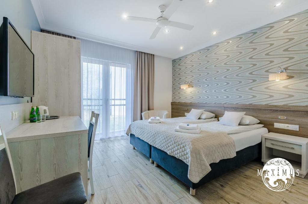 ein Hotelzimmer mit einem Bett und einem Wandbild in der Unterkunft Maximus in Ustka