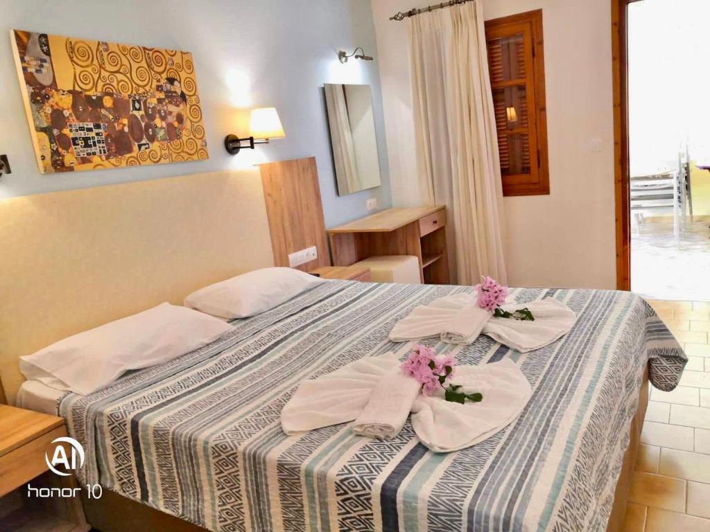 A bed or beds in a room at Hill Lofos Hotel