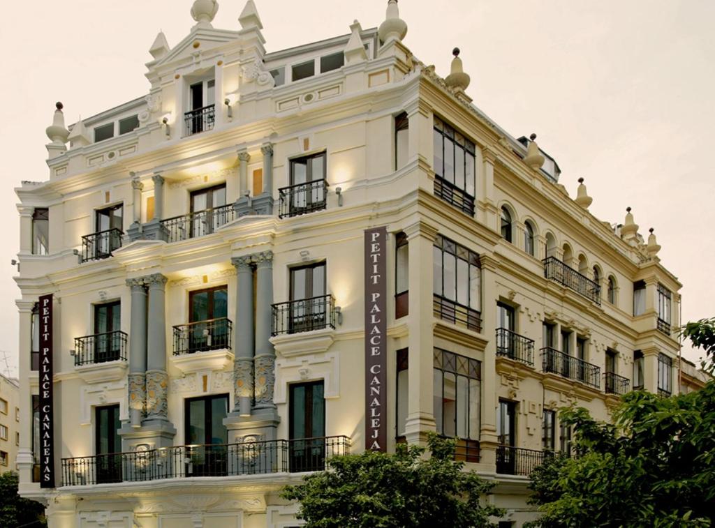 un edificio blanco con un cartel delante en Petit Palace Canalejas Sevilla en Sevilla