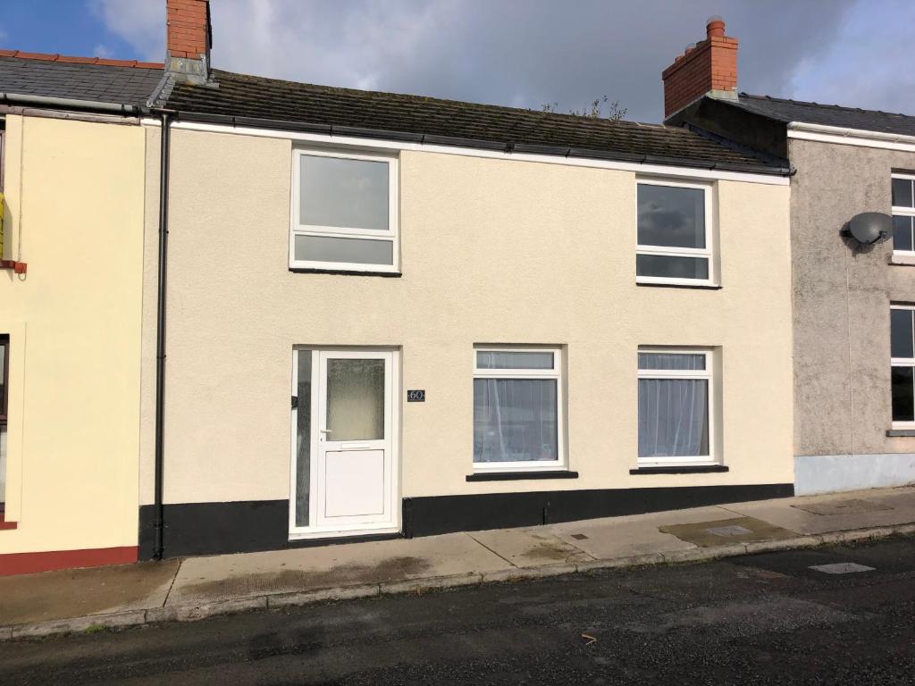una casa con una puerta blanca en una calle en Cleddau View, en Milford Haven