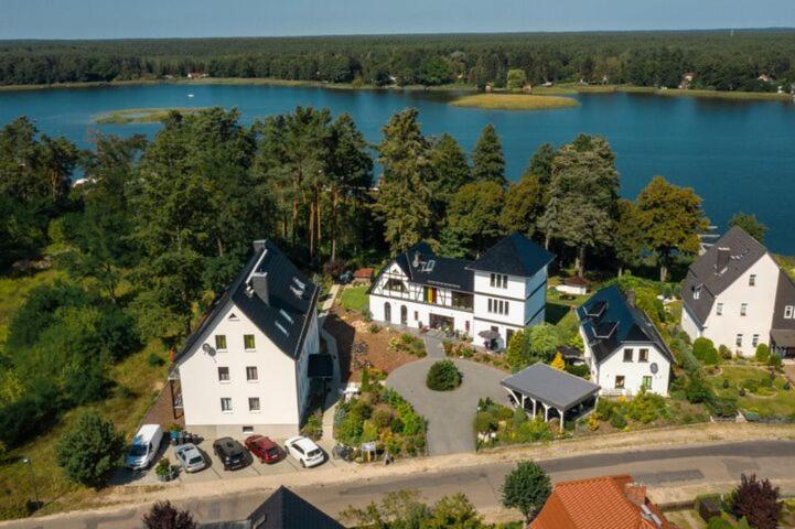 eine Luftansicht eines Hauses mit See in der Unterkunft Röblinseeterrassen in Fürstenberg-Havel