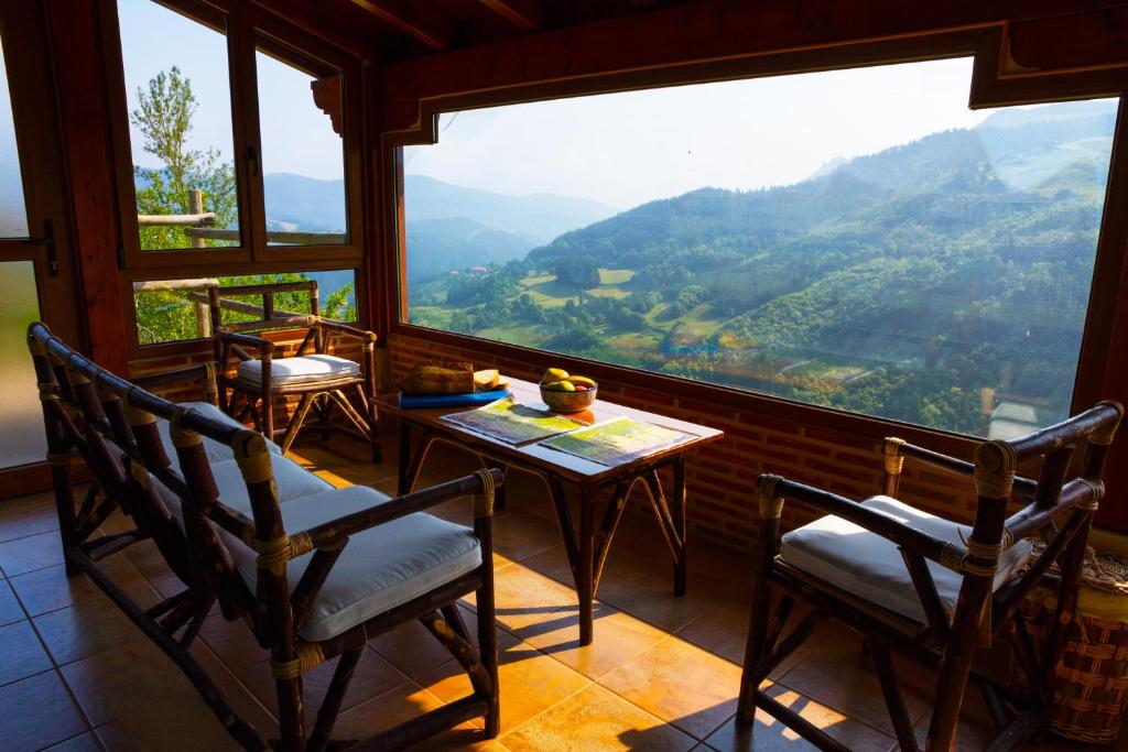 Leintz-GatzagaにあるAterbeのテーブルと椅子、大きな窓が備わる客室です。