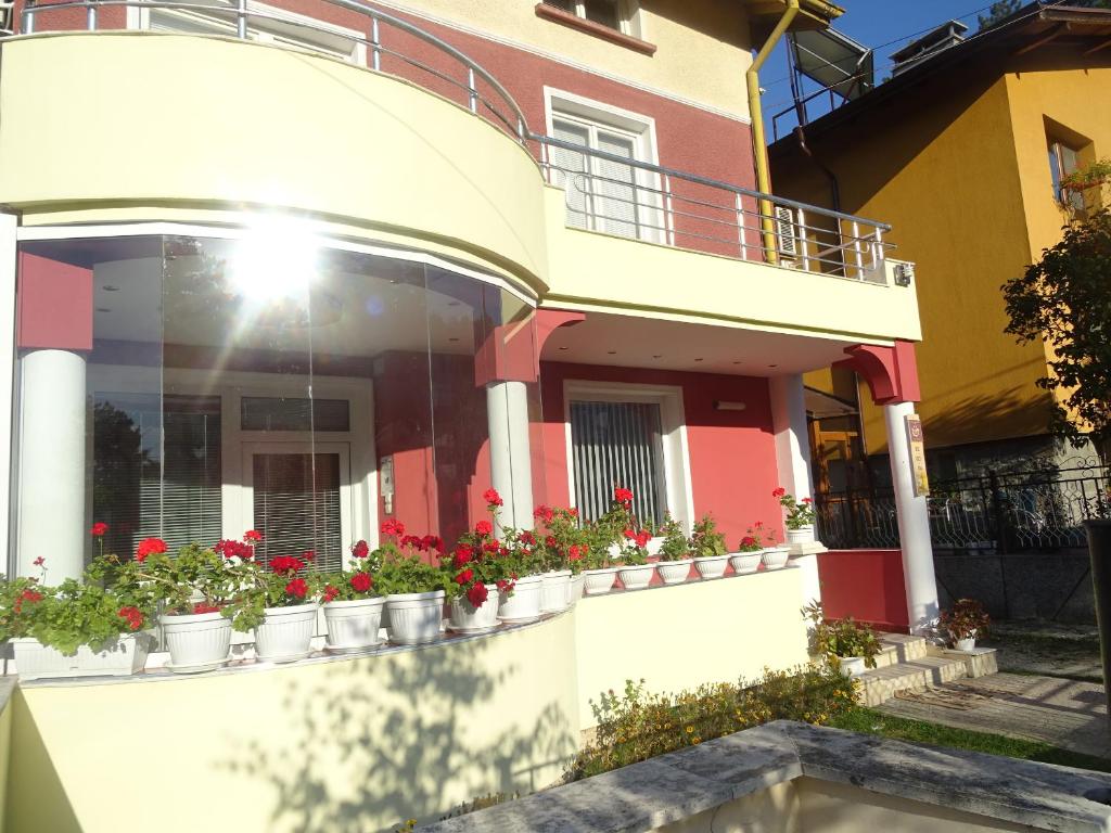 a house with potted plants on the side of it at Стаи за гости Ве-Бо-Ли** in Bankya