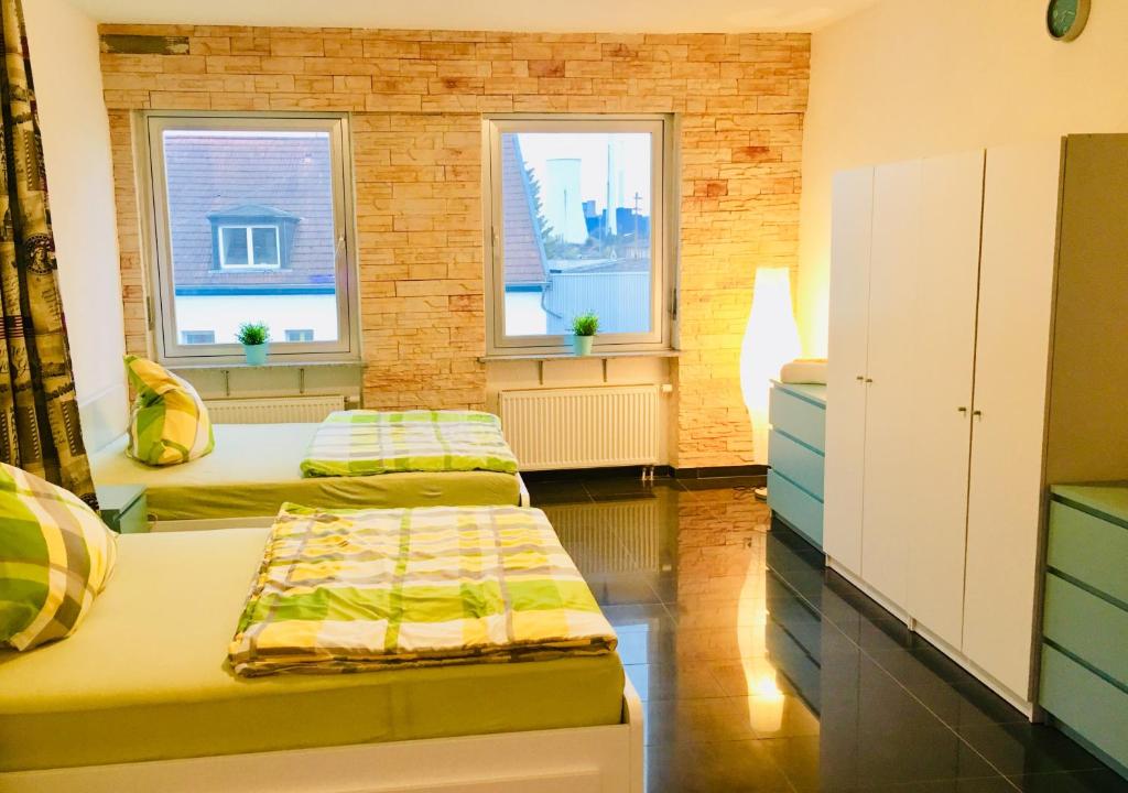2 Betten in einem Zimmer mit 2 Fenstern in der Unterkunft Gästehaus Don Camillo in Ensdorf