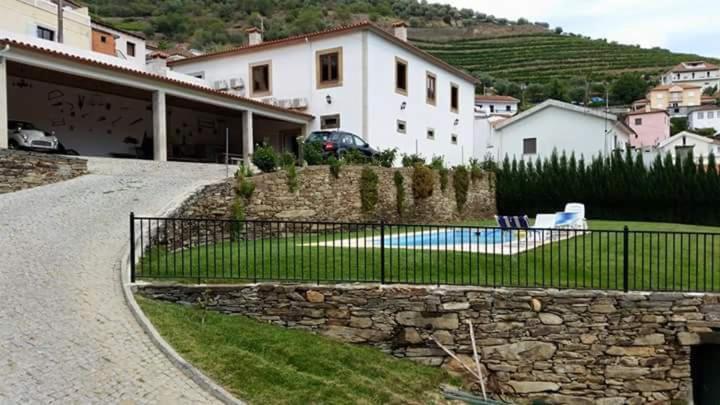 een huis met een hek en een zwembad bij Casa grande Covelinhas in Covelinhas