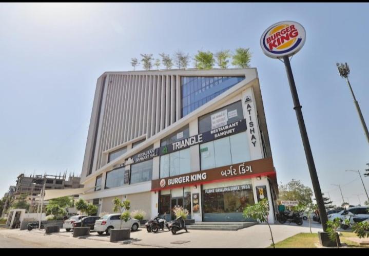 een gebouw met een hamburgerkoning bord ervoor bij Hotel rr palace in Ahmedabad