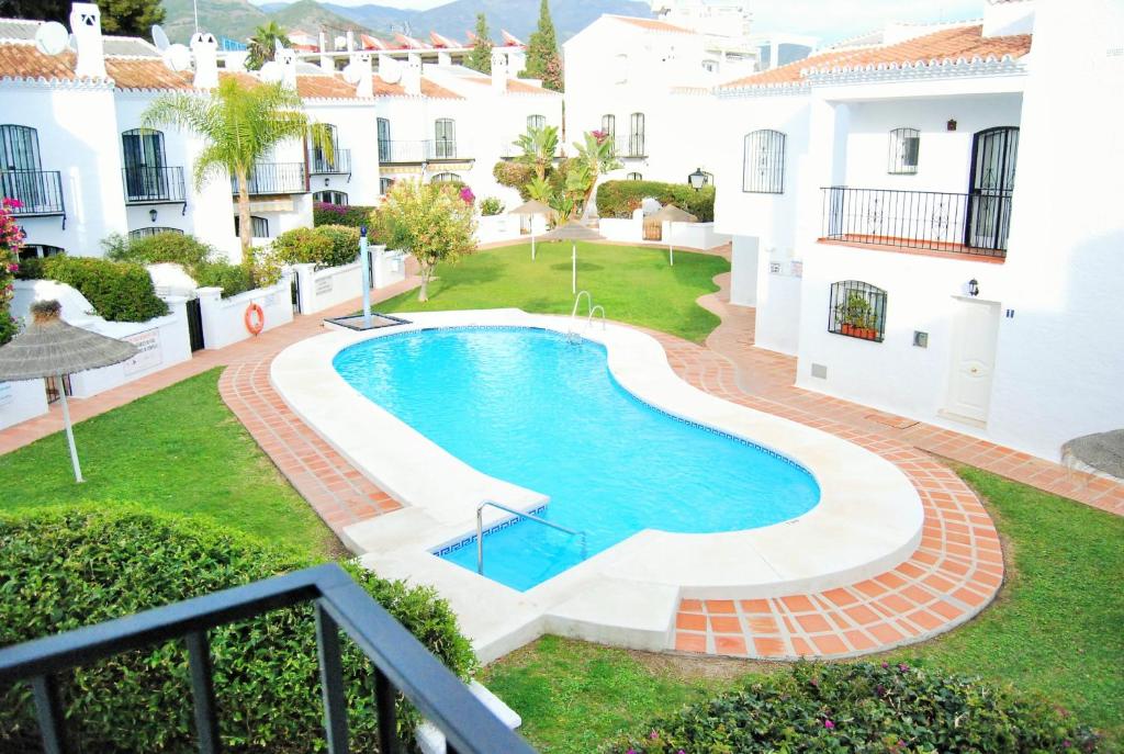 an image of a swimming pool in the yard of a house at Los Pinos 29 Villas Casasol in Nerja