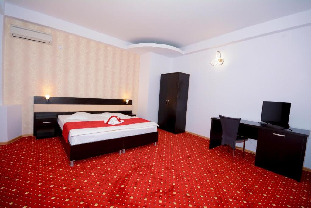 a bedroom with a bed and a red carpet at Hotel Magic - City Center in Piteşti