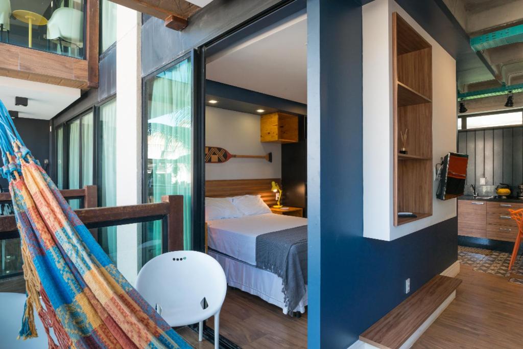 um quarto com uma cama e uma varanda com uma rede de descanso em MEREPE SUÍTES em Porto de Galinhas