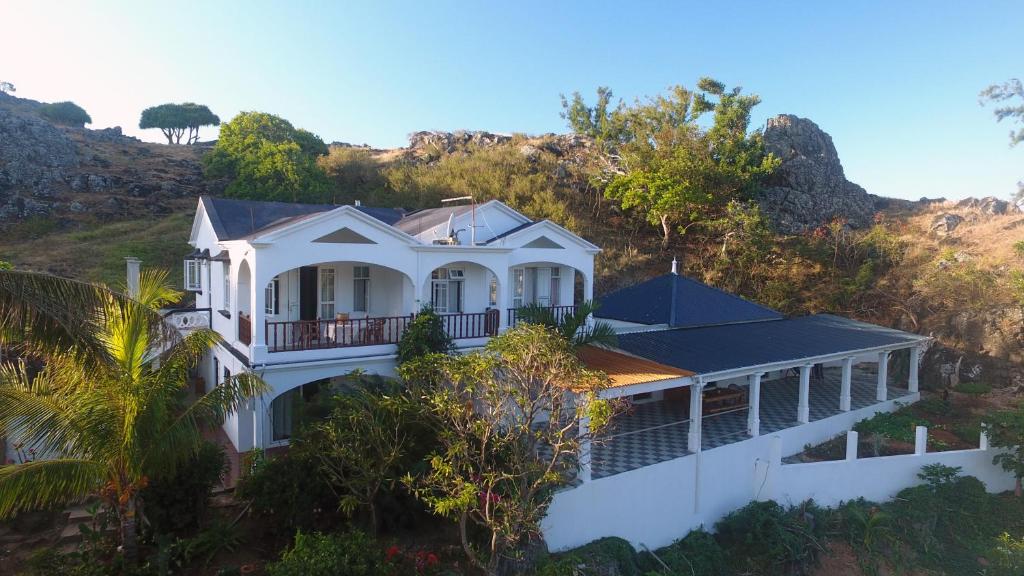 uma casa branca no topo de uma colina em La Villa Allamanda em Rodrigues Island