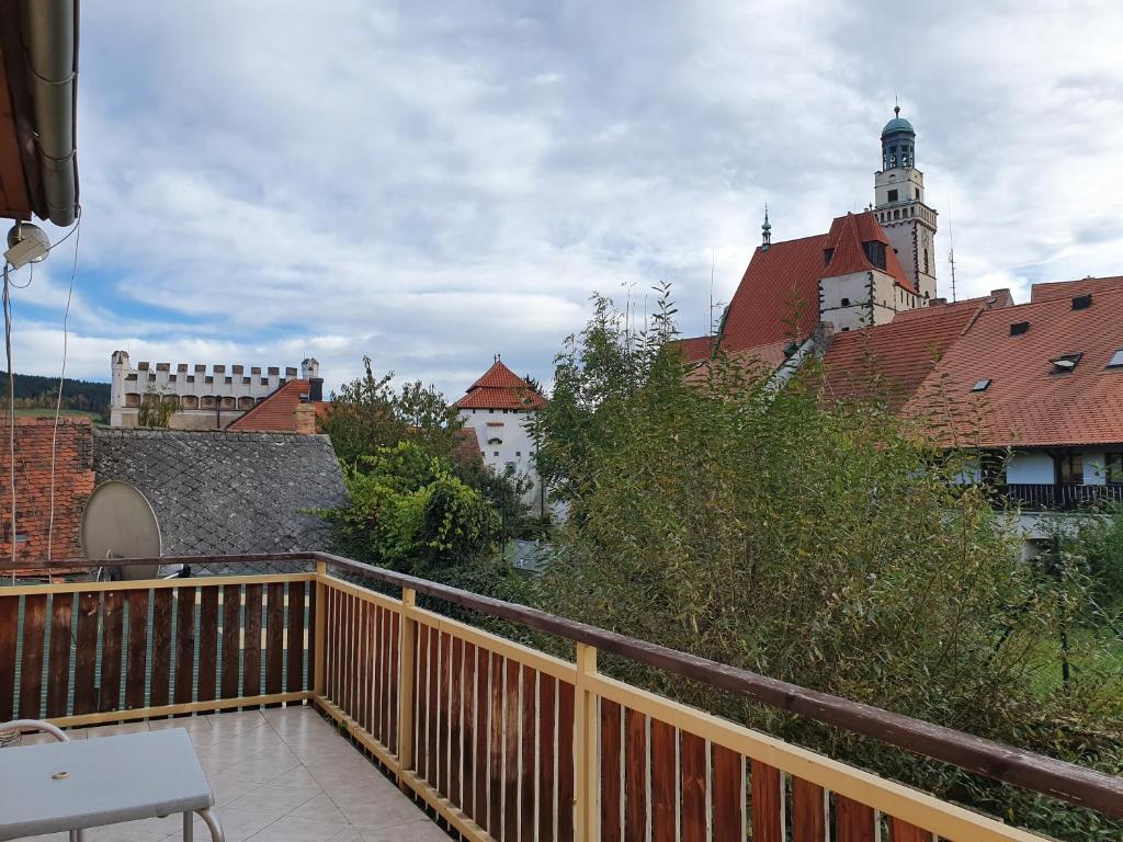 uma varanda com vista para um edifício com uma torre do relógio em Apartmany U Lva em Prachatice