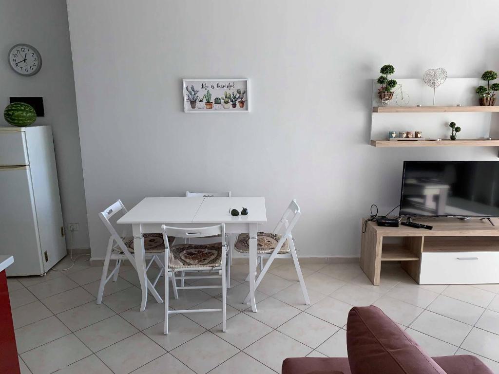 una mesa blanca y sillas en la sala de estar. en The Sunset Apartament, en Durrës