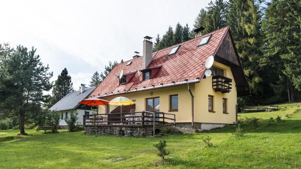 une grande maison jaune avec un toit rouge dans l'établissement Chata Hansenka, à Lipno nad Vltavou