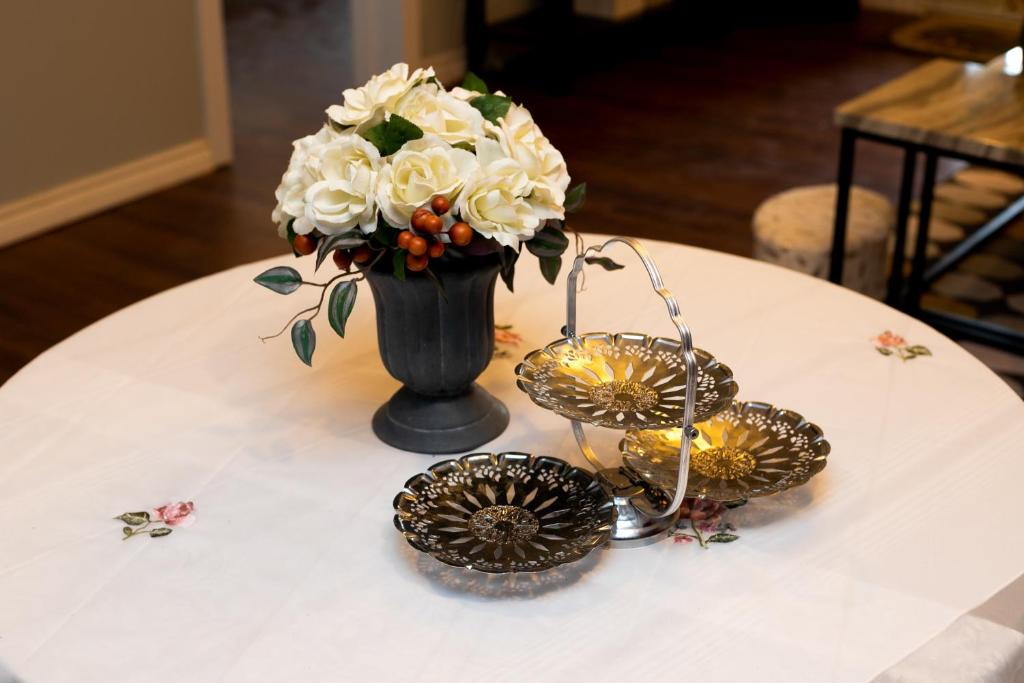 a black vase with white flowers on a table at Lily's garden in Charlottetown