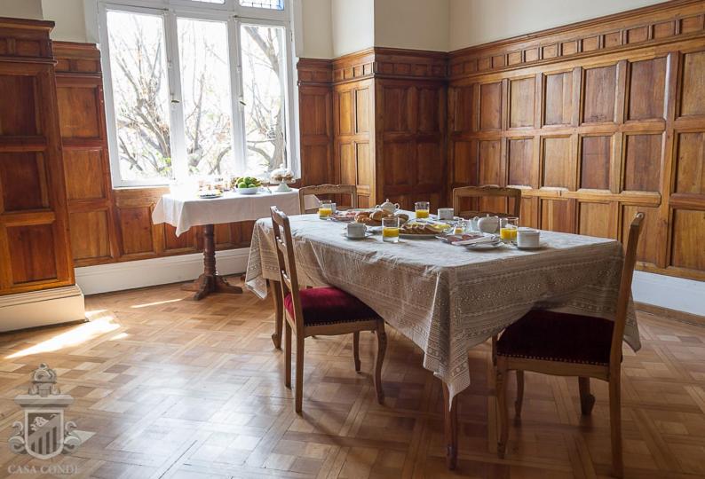 a dining room with a table with chairs and a window at Hotel Boutique Casa Conde in Santiago