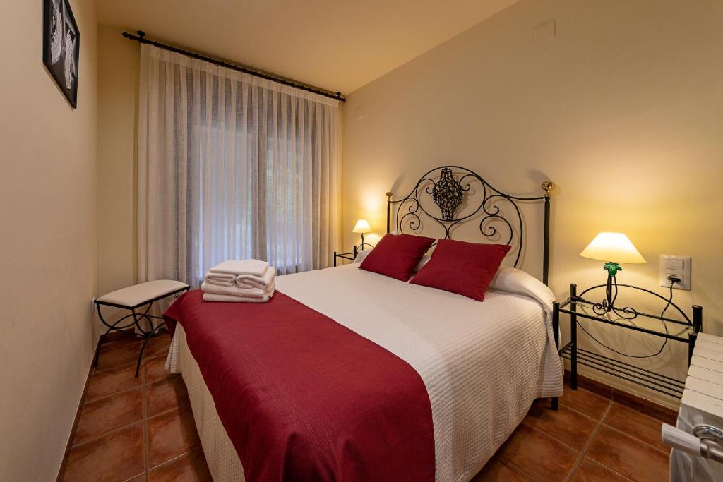 a bedroom with a large bed with red pillows at Casa El Sastre III in Beceite