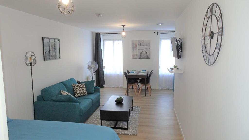 sala de estar con sofá azul y mesa en Appartement cosy proche gare, en Vierzon